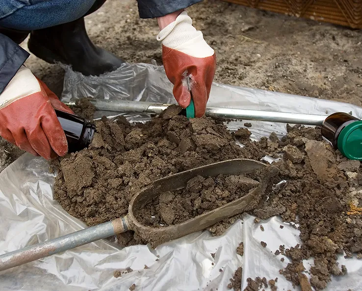 soil-scoop-jar-dig-sm A person wearing gardening gloves scooping soil